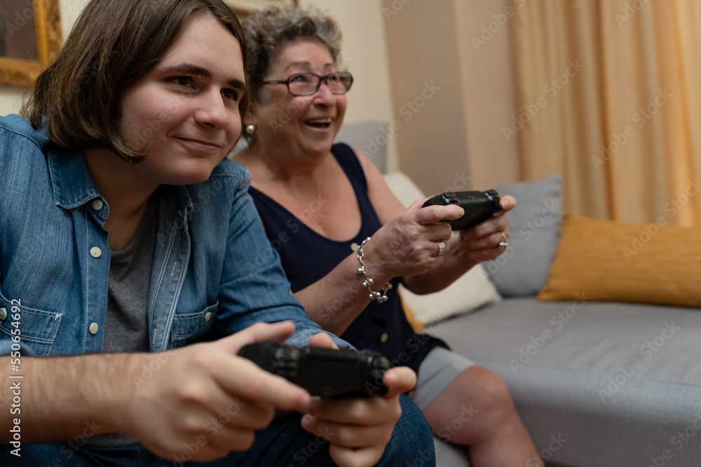 Grandma and grandson having fun playing video games at home. Grandma and grandson having fun playing video games at home.