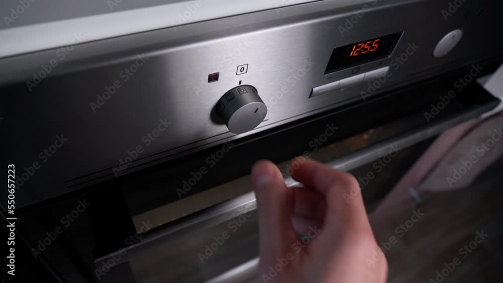 Close up men hand setting cooking mode or temperature on oven. Selective focus Close up men hand setting cooking mode or temperature on oven. Selective focus