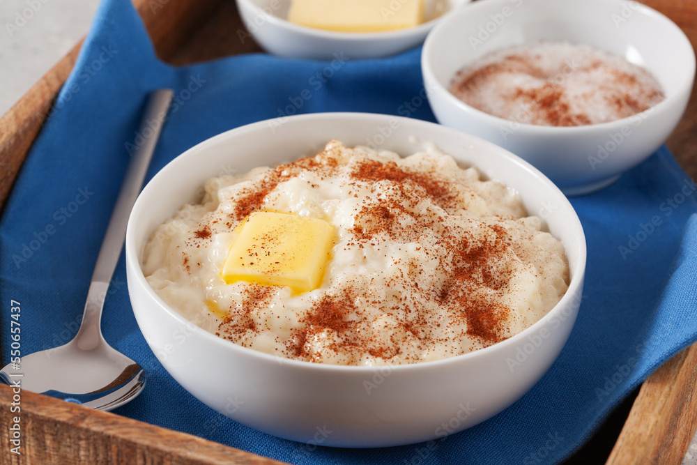rice pudding with butter cinnamon. french riz au lait, norwegian risgrot, traditional breakfast dessert rice pudding with butter cinnamon. french riz au lait, norwegian risgrot, traditional breakfast dessert