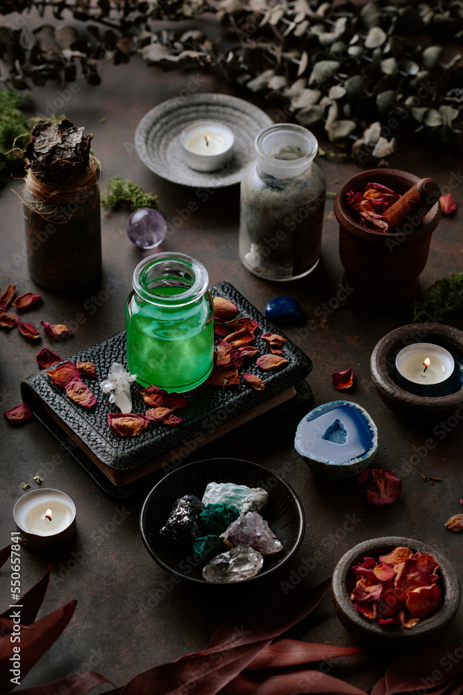Witchcraft still life concept with potion, spell book, herbs ingredients candles and magical equipment