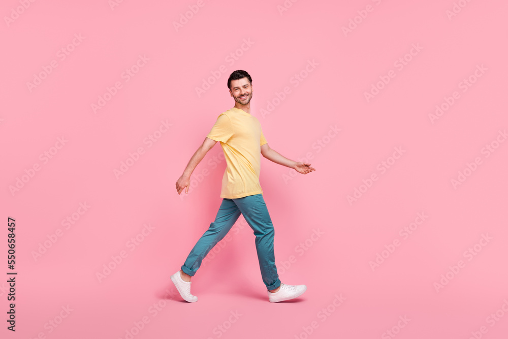 Full length photo of optimistic attractive man dressed comfort clothes going moving empty space isolated on pink color background
