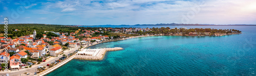 Petrcane village tourist destination coastline aerial panoramic view, Dalmatia region of Croatia. Aerial top view of village Petrcane, Croatia. Petrcane aerial view, Dalmatia region of Croatia © daliu
