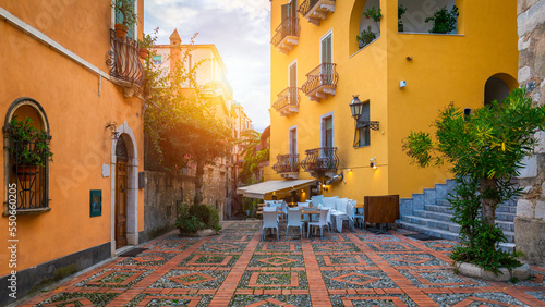 Fototapeta Naklejka Na Ścianę i Meble -  Beautiful old town of Taormina with small streets, flowers. Architecture with archs and old pavement in Taormina. Colorful narrow street in old town of Taormina. Sicily, Italy.