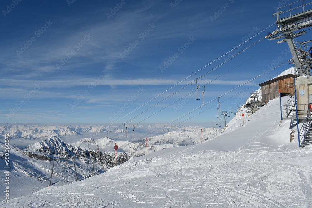 Sunny day on a Hintertux glacier (photo taken from 3250 meters above sea level) with view of Tirol Alps - obrazy, fototapety, plakaty 