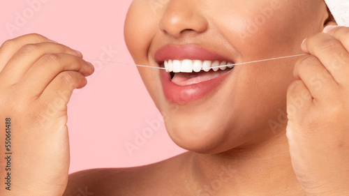 Toothcare and oral treatment concept. Closeup cropped view of unrecognizable black obese woman using dental floss