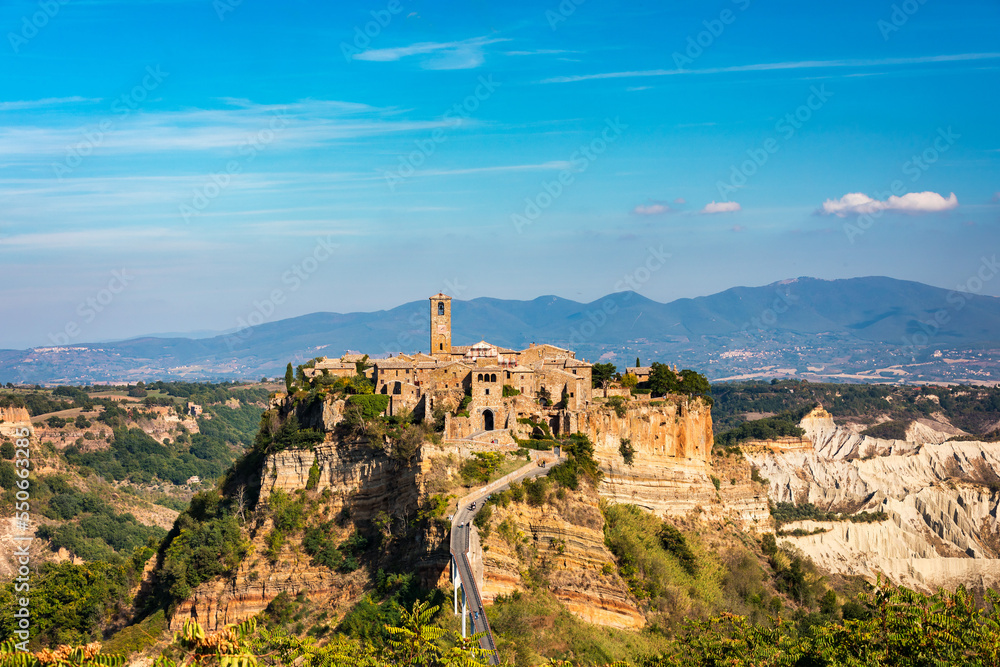 Naklejka premium The famous Civita di Bagnoregio on a sunny day. Province of Viterbo, Lazio, Italy. Medieval town on the mountain, Civita di Bagnoregio, popular touristic stop at Tuscany, Italy.