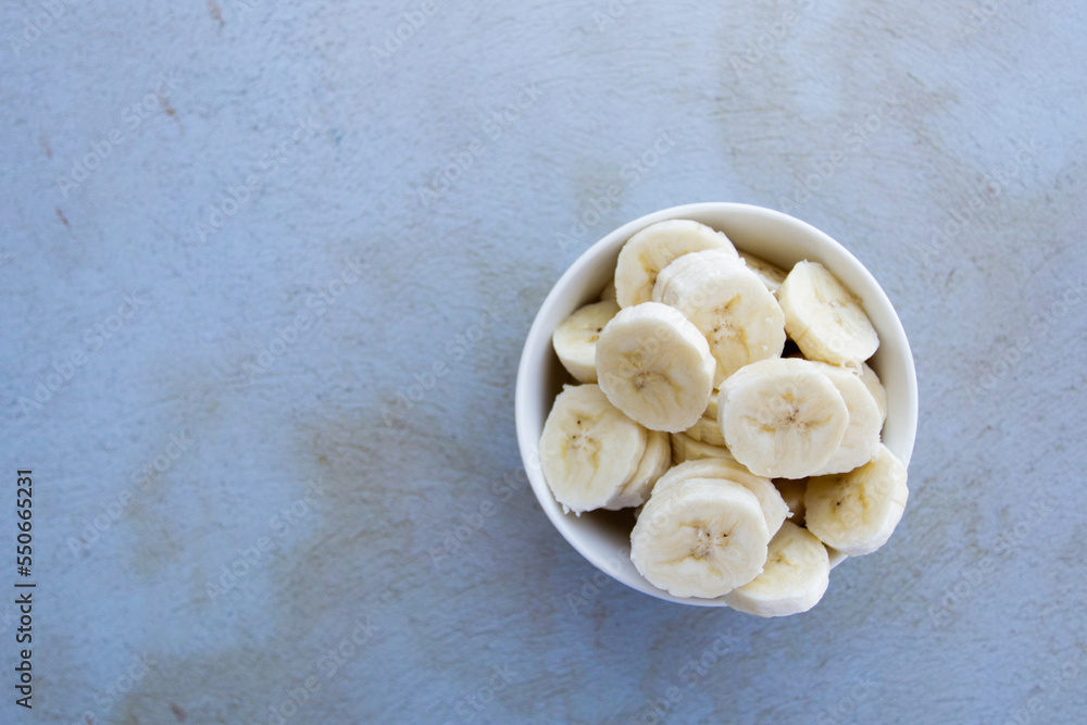 Bowl full of banana slices on an abstract background. Concept of healthy food, fruits. Bowl full of banana slices on an abstract background. Concept of healthy food, fruits.