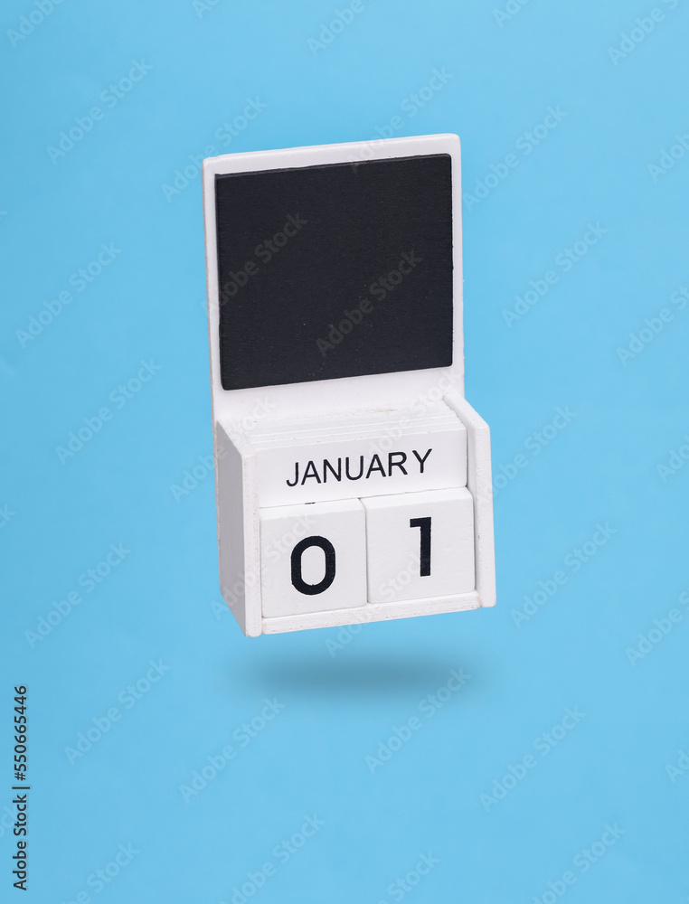 Wooden calendar with january 01 date levitating on a blue background. New Year Wooden calendar with january 01 date levitating on a blue background. New Year