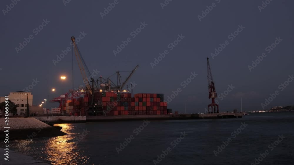 A cargo ship stands in port early at night A cargo ship stands in port early at night