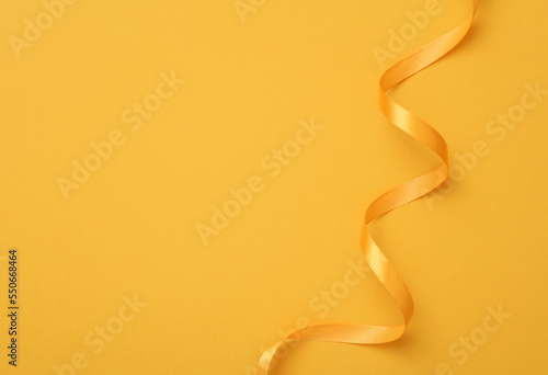 Blank holiday background with satin yellow ribbon. Copy space