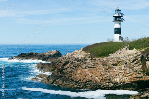 small white and blue lighthouse in town of Galicia, Spain