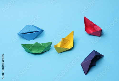 Paper colored boats on a blue background. Business  leadership concept