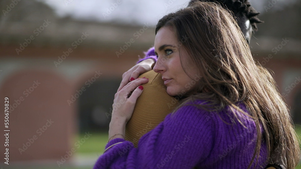Young interracial couple hugging outside. Empathic embrace standing outside at park2 Young interracial couple hugging outside. Empathic embrace standing outside at park2