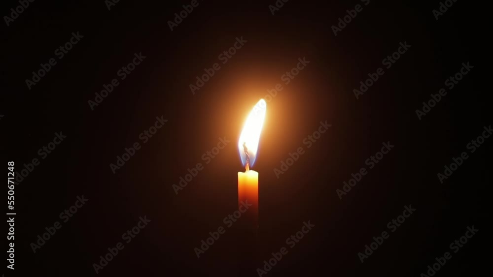 Burning candle on a dark background in slow motion. Burning candle on a dark background in slow motion.