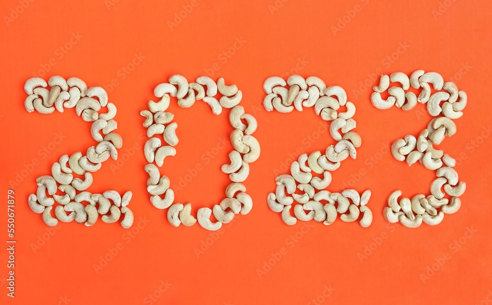 2023 Written with Cashew Nut Isolated on Orange or Red Background in Horizontal Orientation, Happy New Year 2023 Wishing Conceptual Photo