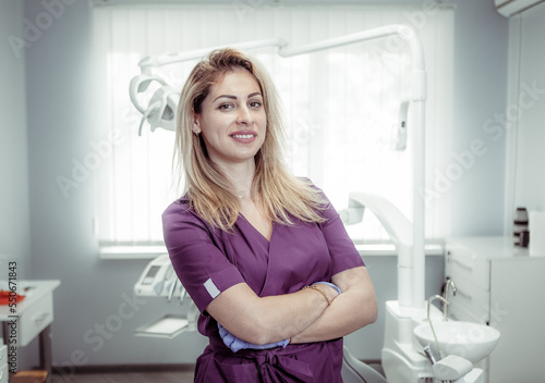 Portrait of confident, smiling female dentist at the dental office