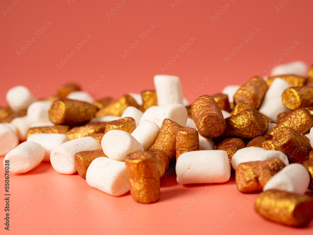 Mini marshmallows on a pink background. Marshmallow gold and white. Mini marshmallows on a pink background. Marshmallow gold and white.