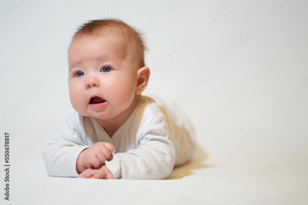 portrait of an infant lying on his back against a white background portrait of an infant lying on his back against a white background