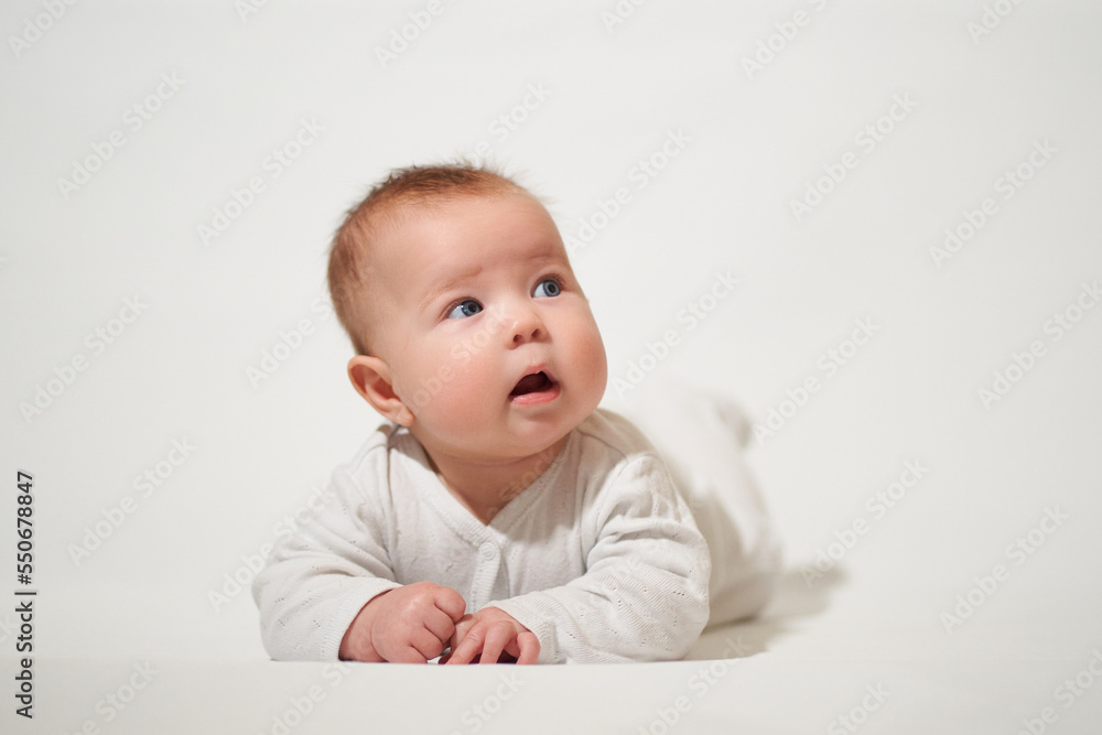 portrait of an infant lying on his back against a white background