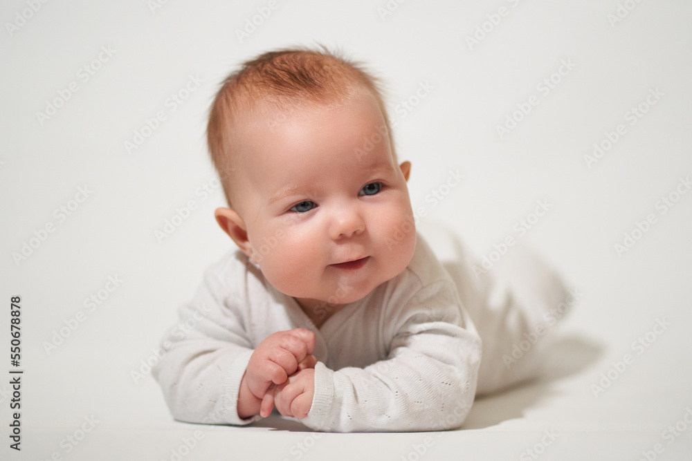 portrait of an infant lying on his back against a white background