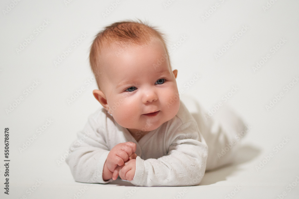 portrait of an infant lying on his back against a white background portrait of an infant lying on his back against a white background