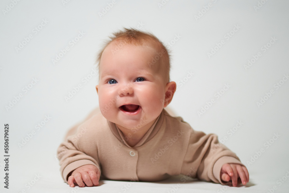 portrait of an infant lying with a cheerful emotion on a white background