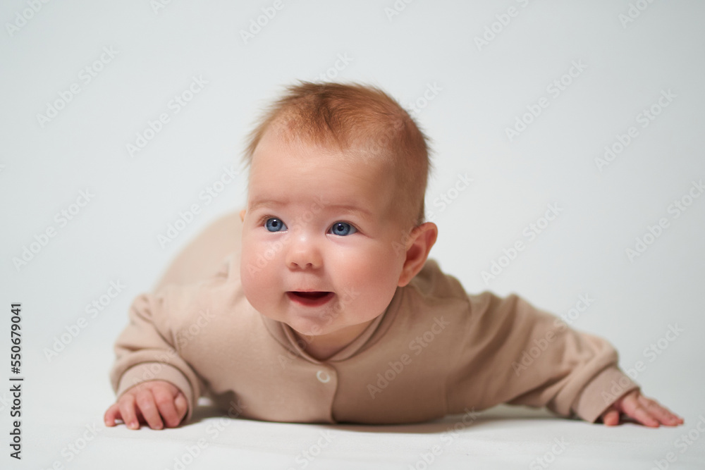 portrait of an infant lying with a cheerful emotion on a white background portrait of an infant lying with a cheerful emotion on a white background