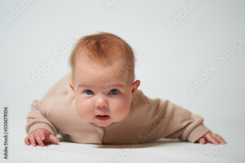 Portrait of an infant learning to crawl on a white background