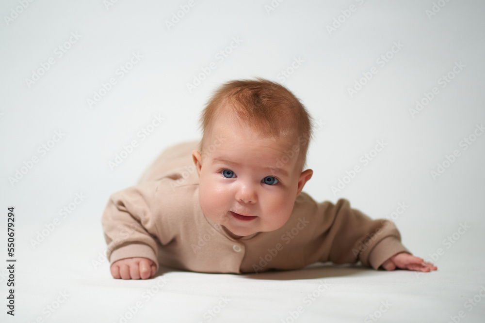 portrait of an infant looking into the camera who is learning to crawl on a white background portrait of an infant looking into the camera who is learning to crawl on a white background