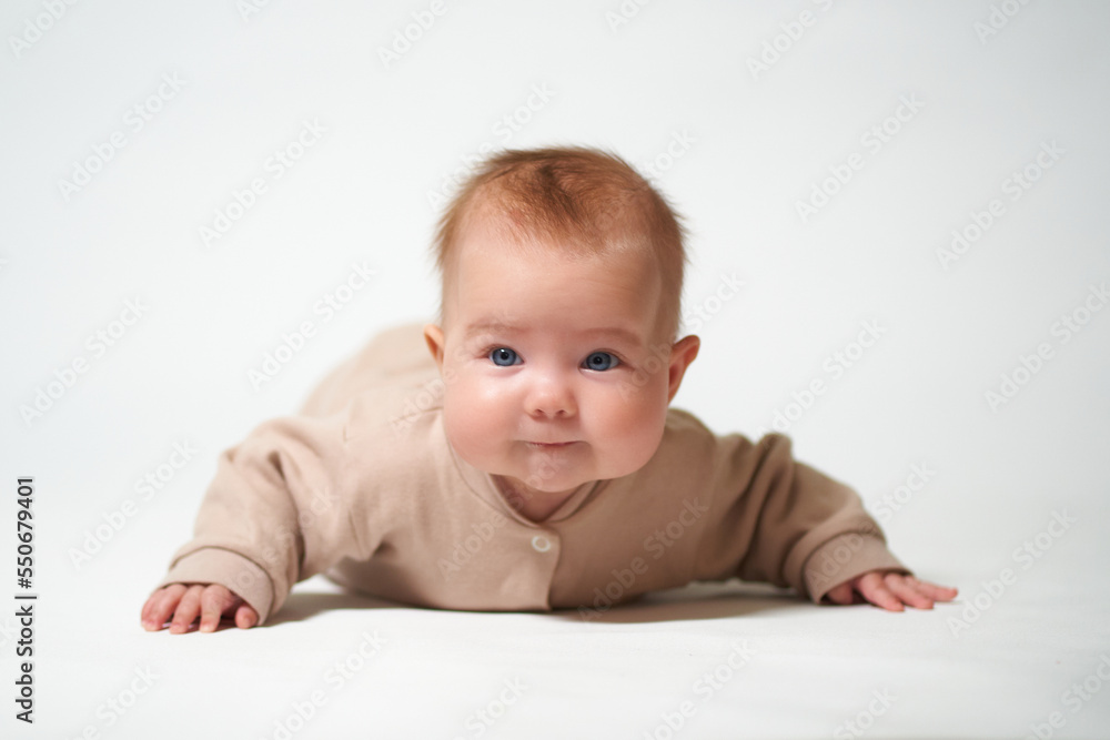 portrait of an infant learning to crawl against a white background portrait of an infant learning to crawl against a white background