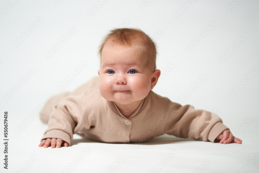 portrait of an infant learning to crawl against a white background portrait of an infant learning to crawl against a white background