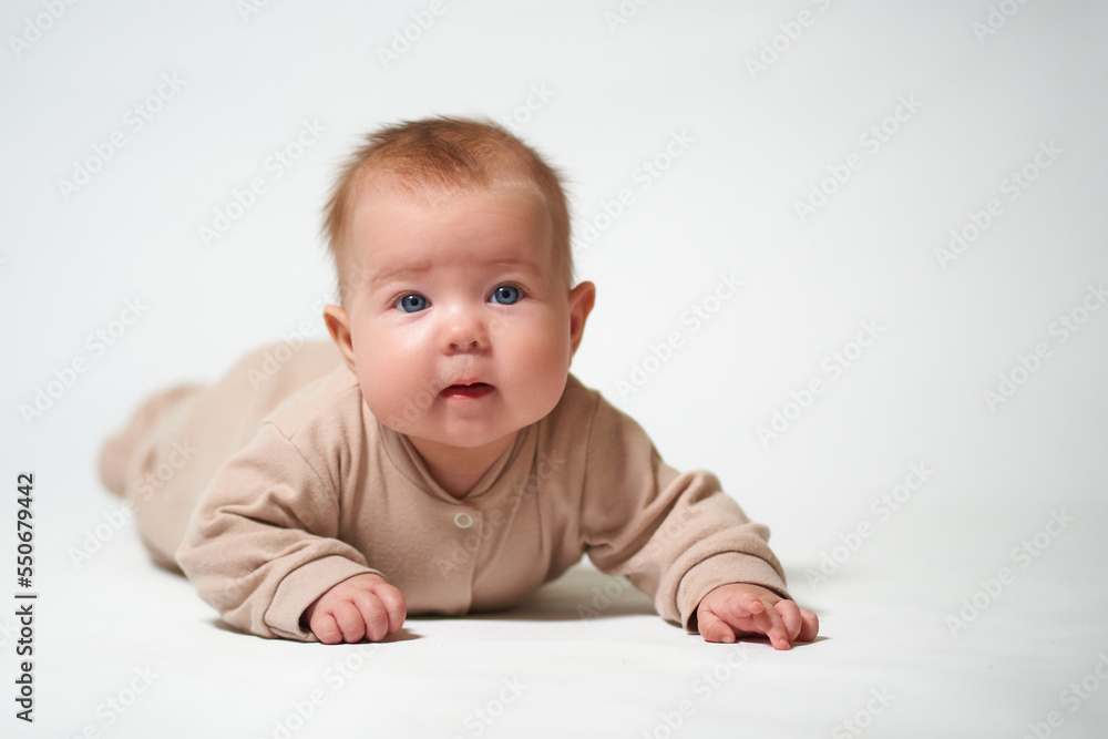 portrait of an infant learning to crawl against a white background portrait of an infant learning to crawl against a white background