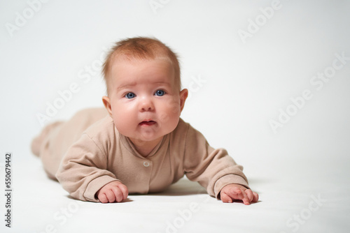 portrait of an infant learning to crawl against a white background