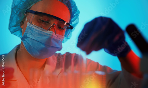 Female scientist working with test tubes in lab.