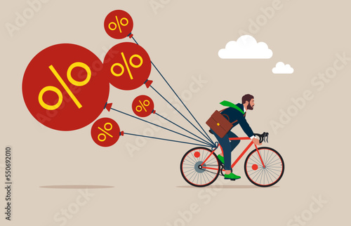 Businessman Riding a bicycle tries to pull down many inflation balloons. Reserve try to tame inflation down by interest rate hike. Stop inflation, Inflation bubble.  photo