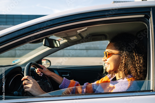 Wallpaper Mural Portrait of smiling young african american woman driving a car Torontodigital.ca