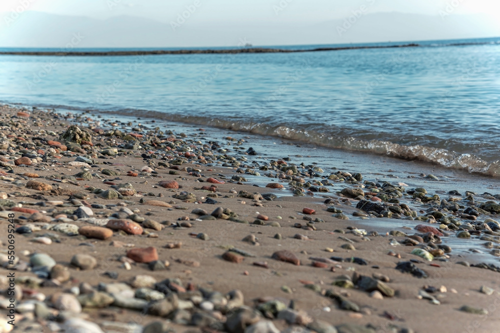 Rocks on the beach with wavey blue ocean, close up Rocks on the beach with wavey blue ocean, close up