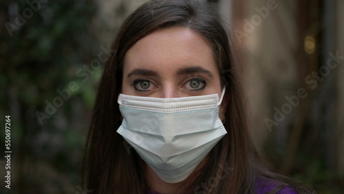 Young woman putting covid-19 face mask. Girl wears surgical mask
