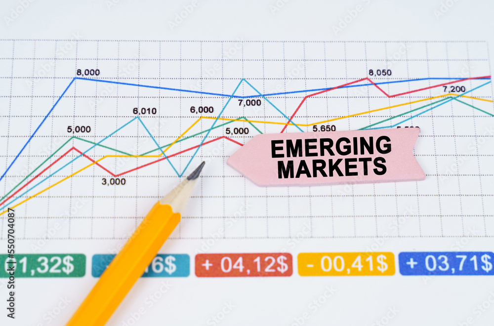 On business charts there is a pencil and an arrow sticker with the inscription - EMERGING MARKETS