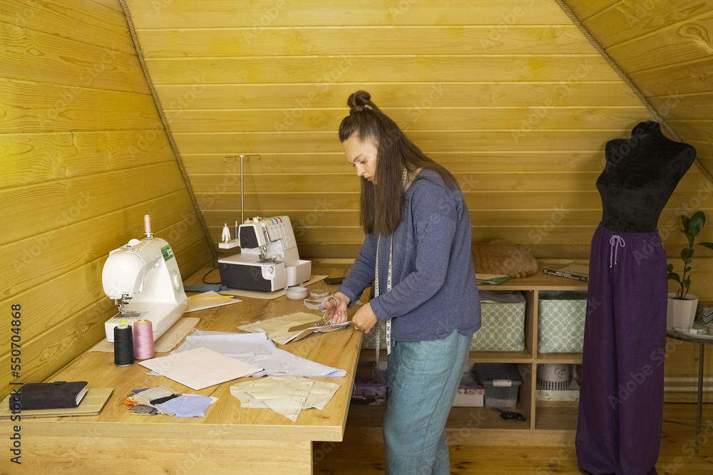 The fashion designer cuts the fabric according to patterns with scissors. The fashion designer cuts the fabric according to patterns with scissors.