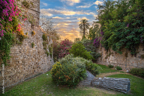 Park with flowers decorations, at city walls fortifications. Liberty Gate, Rhodes old town, Greece photo