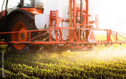 Tractor spraying soybean crops field