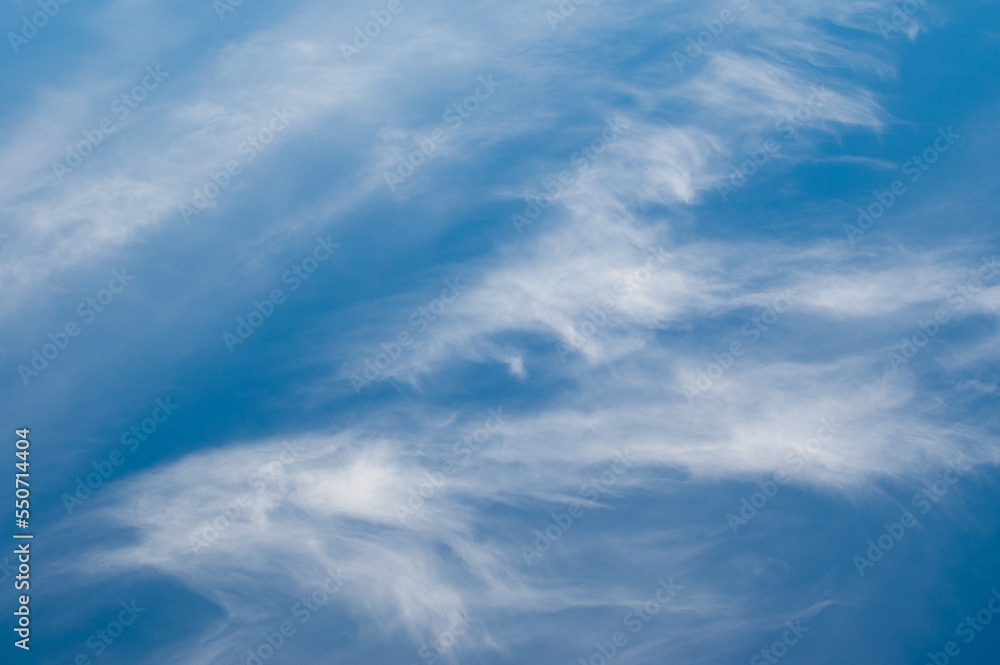 blue sky and white clouds, in the photo feather clouds on a blue background
