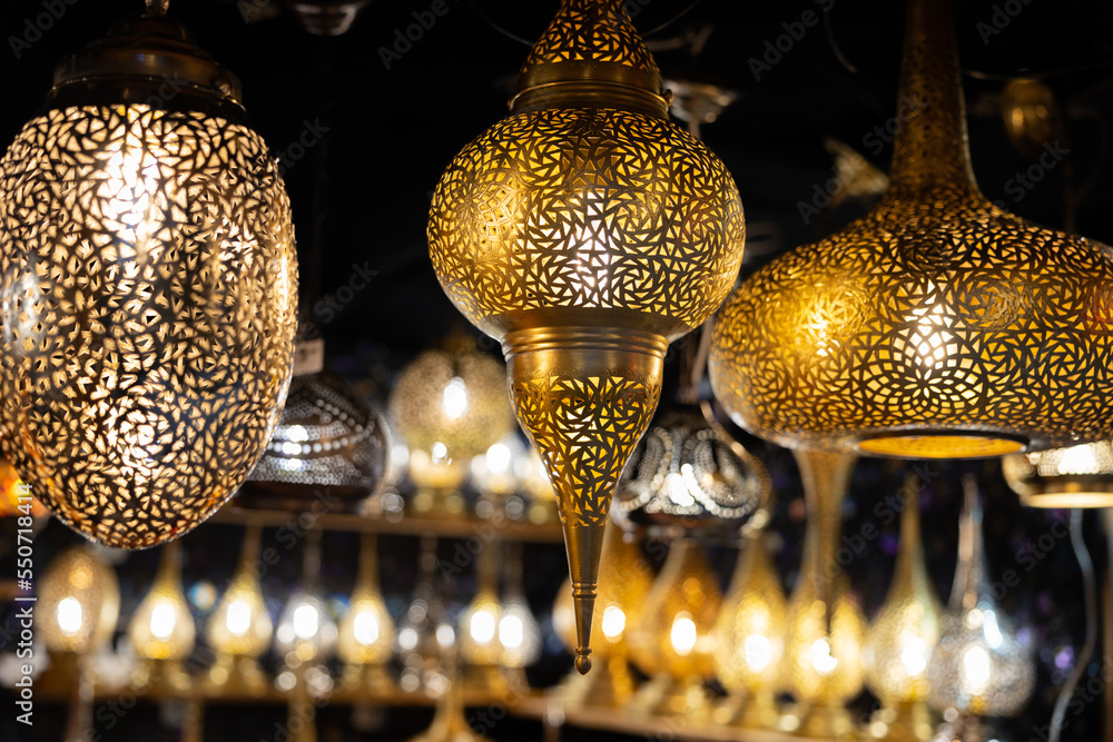 Bright openwork hanging metal lamps of an unusual shape - obrazy, fototapety, plakaty 