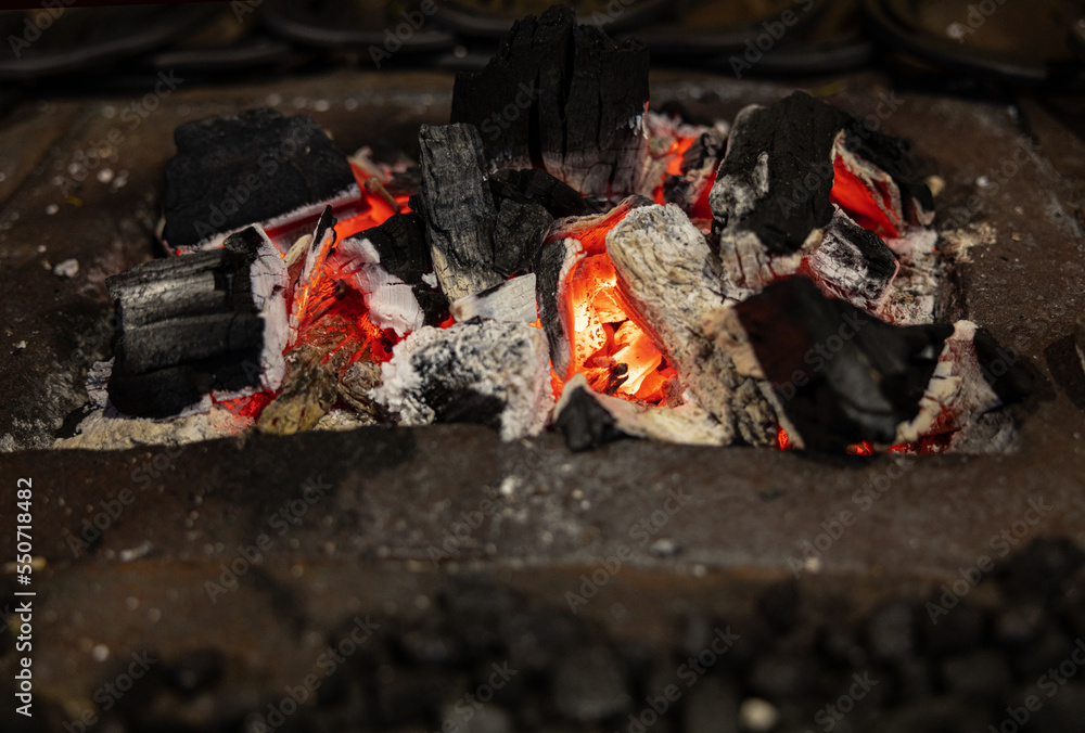Picturesque burning bright coals smolder in a metal stand Picturesque burning bright coals smolder in a metal stand