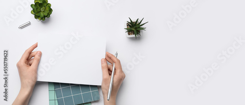 Female hands with blank pap...