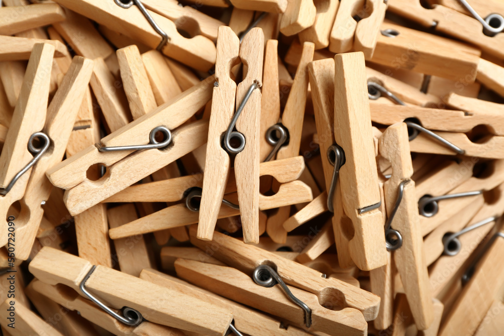 Heap of wooden clothespins as background, closeup