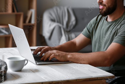 Soldier in wheelchair using laptop at home, closeup