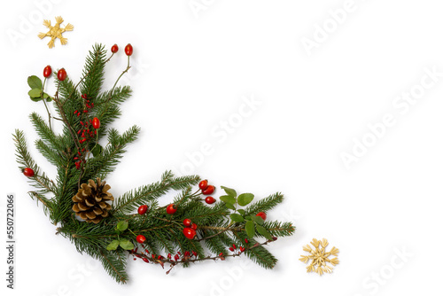 Rustic christmas corner - decoration of  green spruce, barberry twigs and wild rose fruits with straw stars, flat lay with copy space