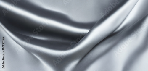 Silver silk fabric that is smooth, shiny, and glittering with a metallic sheen. folds and pleats with the light reflecting off its shimmering surface. eye-catching, and luxurious. Generative AI